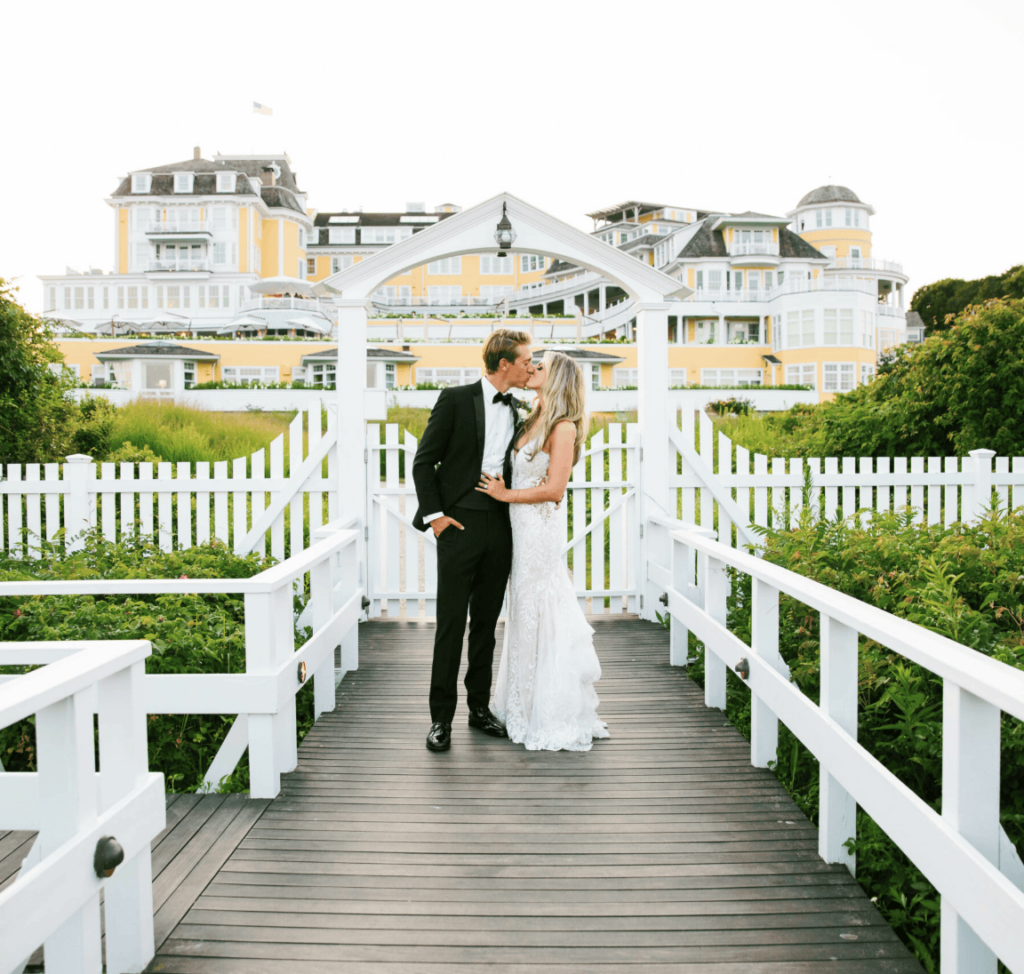 married couple kidding in front of the ocean house