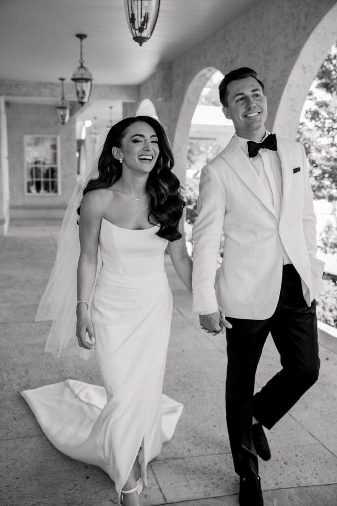 Bride and groom walking through gardens at Renault Winery during summer vineyard wedding in New Jersey