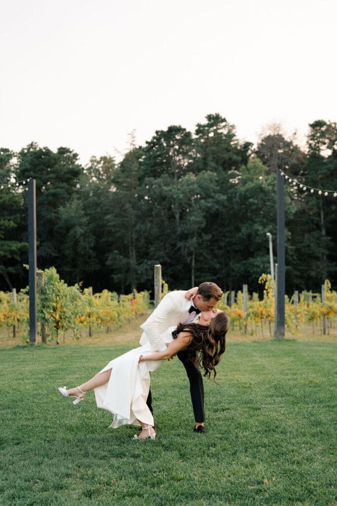 Bride and groom walking through gardens at Renault Winery during summer vineyard wedding in New Jersey